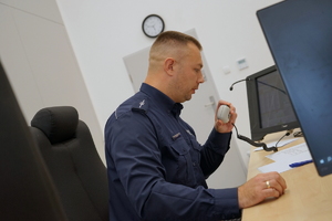 policjant siedzi przed monitorem