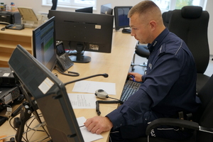 policjant siedzi przed monitorem