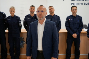 Nieumundurowany policjant gratuluje zwycięzcom i podaje nagrody